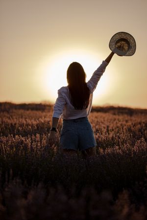 Anonymous woman walking in lavender field