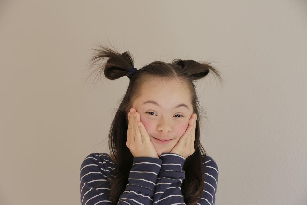 Portrait of female child holding her cheeks with both hands