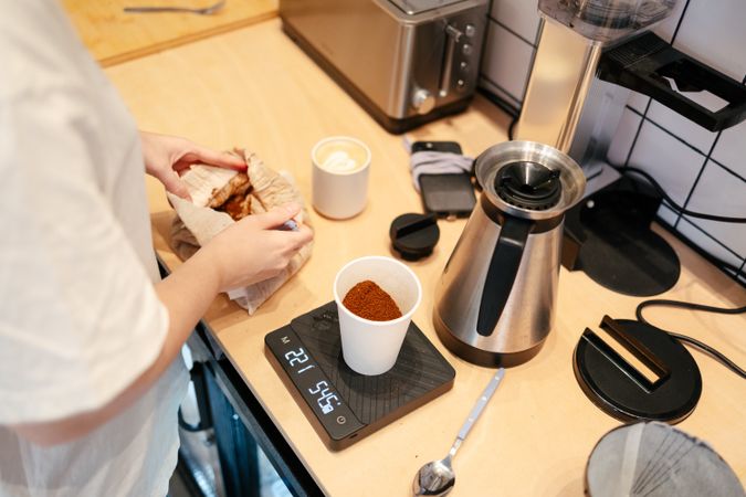 Young barista weighing coffee