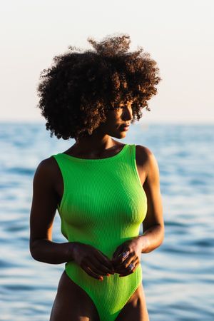dreamy Black woman standing in sea during summer vacation