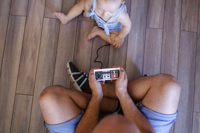 Anonymous father and baby playing video games