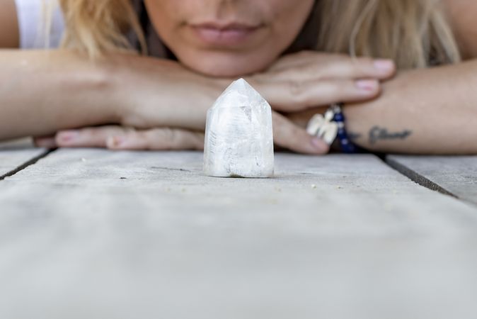 Close up of a quartz crystal with a woman behind.