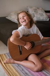 Girl with guitar having fun at home