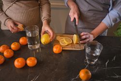 Crop women cutting fruits in kitchen
