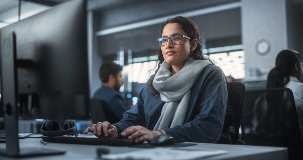 Portrait of a Thoughtful South Asian Engineer Working on Computer in a Technological Corporate Office.