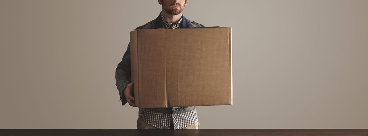 Man holding cardboard box, wide