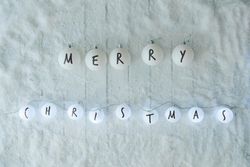 Snowy with partially lit ball decorations reading “Merry Christmas”
