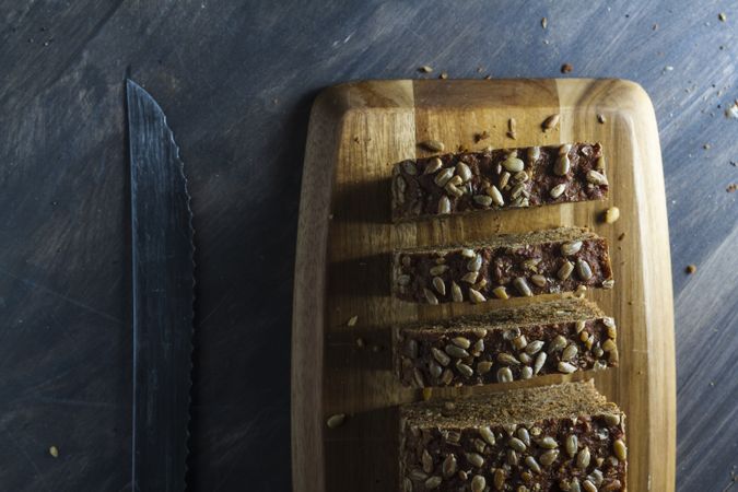 Sliced wholegrain bread on wooden cutting board