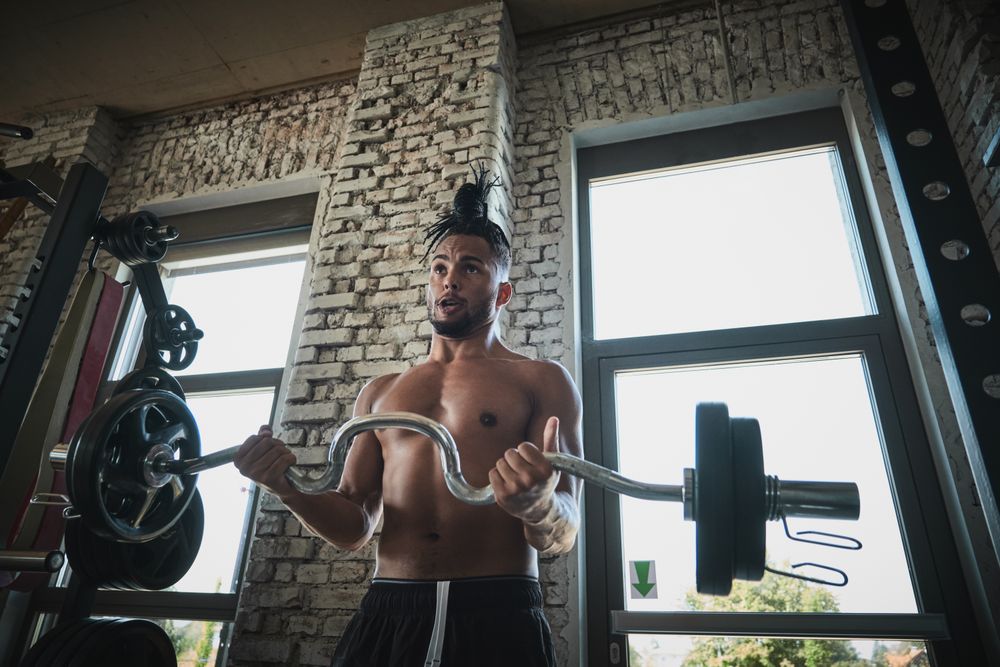Black man exercising with barbell in gym