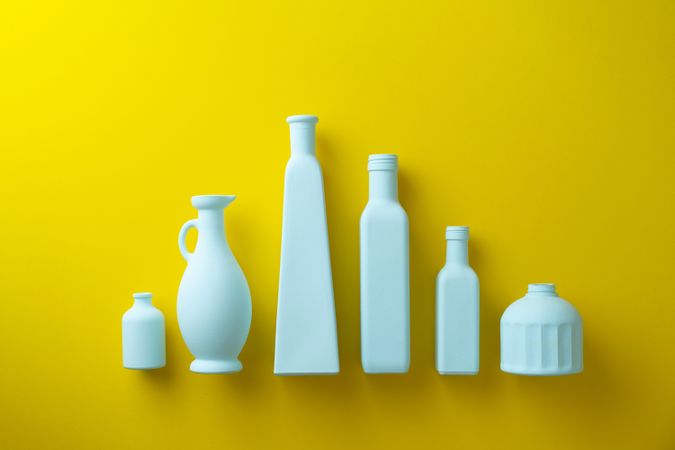 Painted glass bottles on yellow background