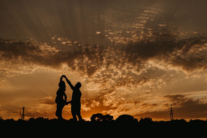 Anonymous couple dancing during sunset