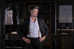 Mature businessman in suit standing at home