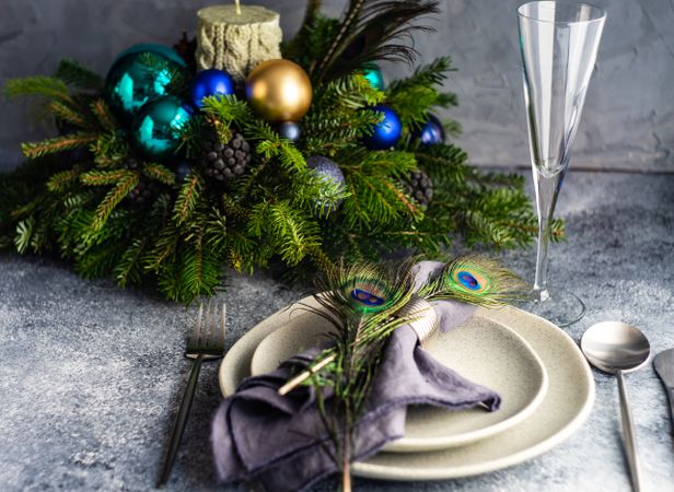 Festive table setting for Christmas dinner with peacock feathers