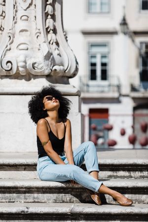 Black female sitting on stairs outdoors