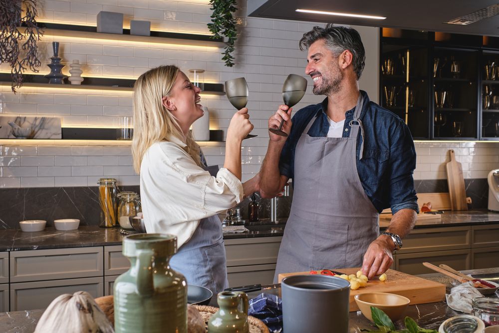 Cheerful funny couple cooking in kitchen