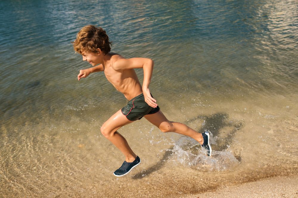Tanned kid having fun on beach