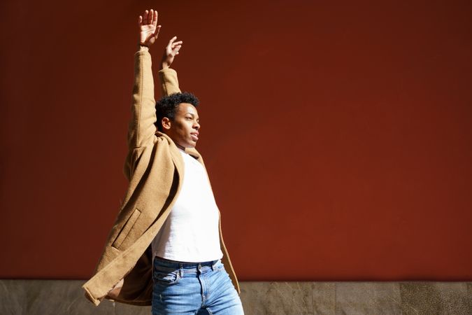 Black male with arms above his head