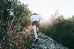 Rearshot of man running up rocky path
