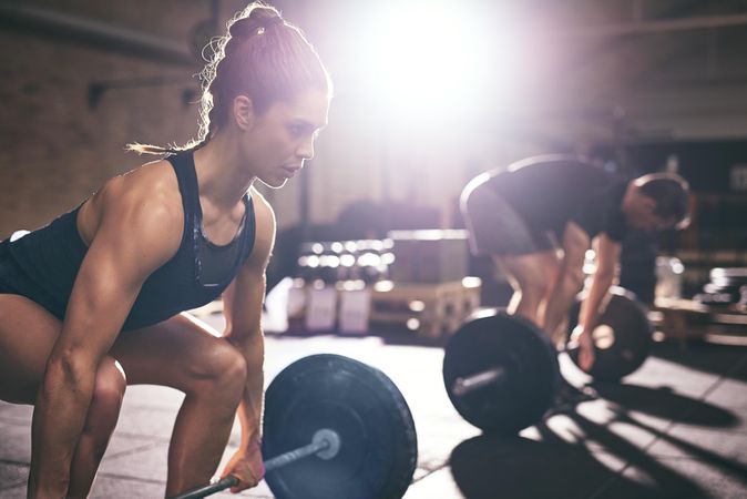 Focused woman preparing to lift heavy barbell