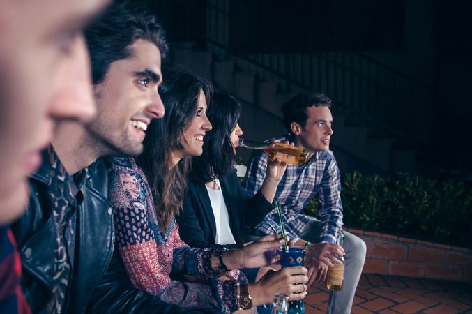 Woman drinking beer with her friends at a party