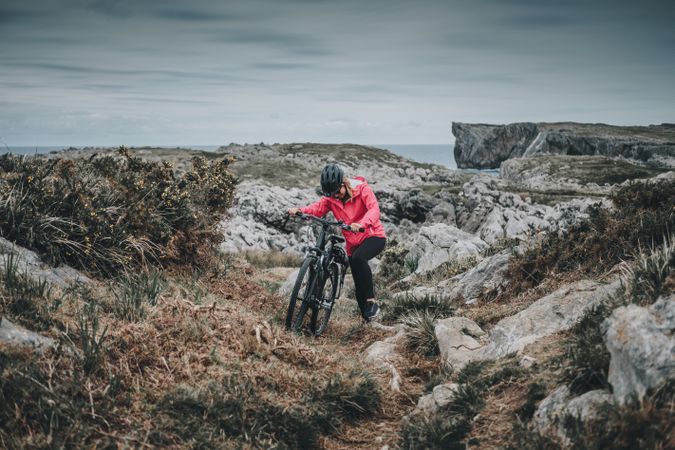 Anonymous female bicyclist on rocks