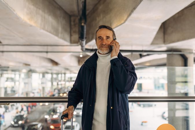 Older man speaking on phone in underpass