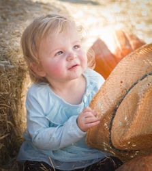 Adorable Baby Girl with Cowboy Hat at the Pumpkin Patch.