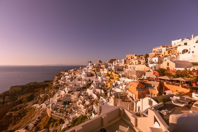 Buildings on a cliff overlooking the sea at sunset