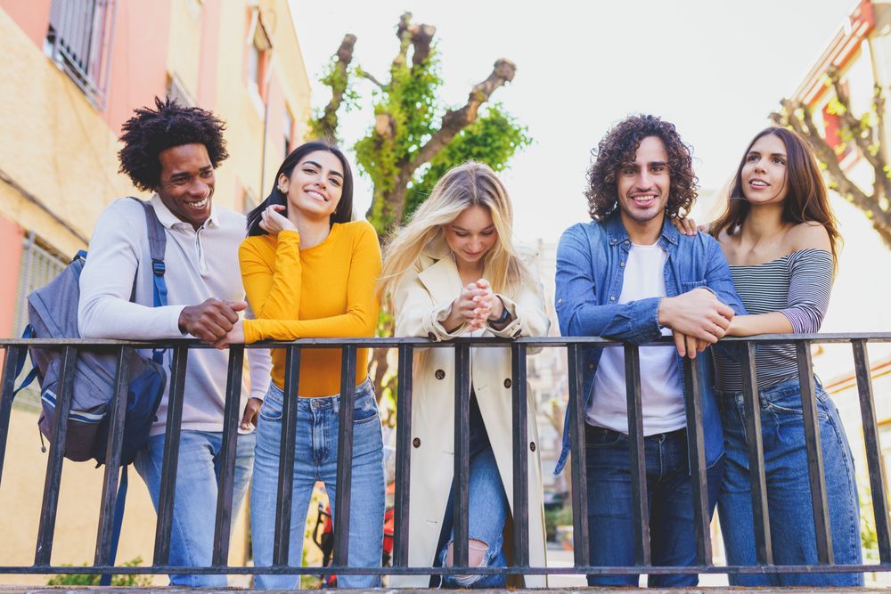 Male and female friends smiling with each other outside