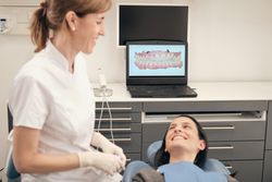 Cheerful female dentist and client after 3D scanning