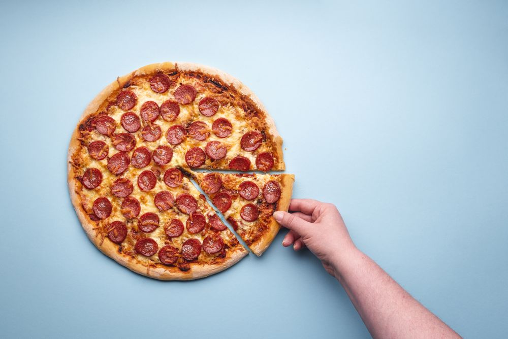 Grabbing a slice of pepperoni pizza