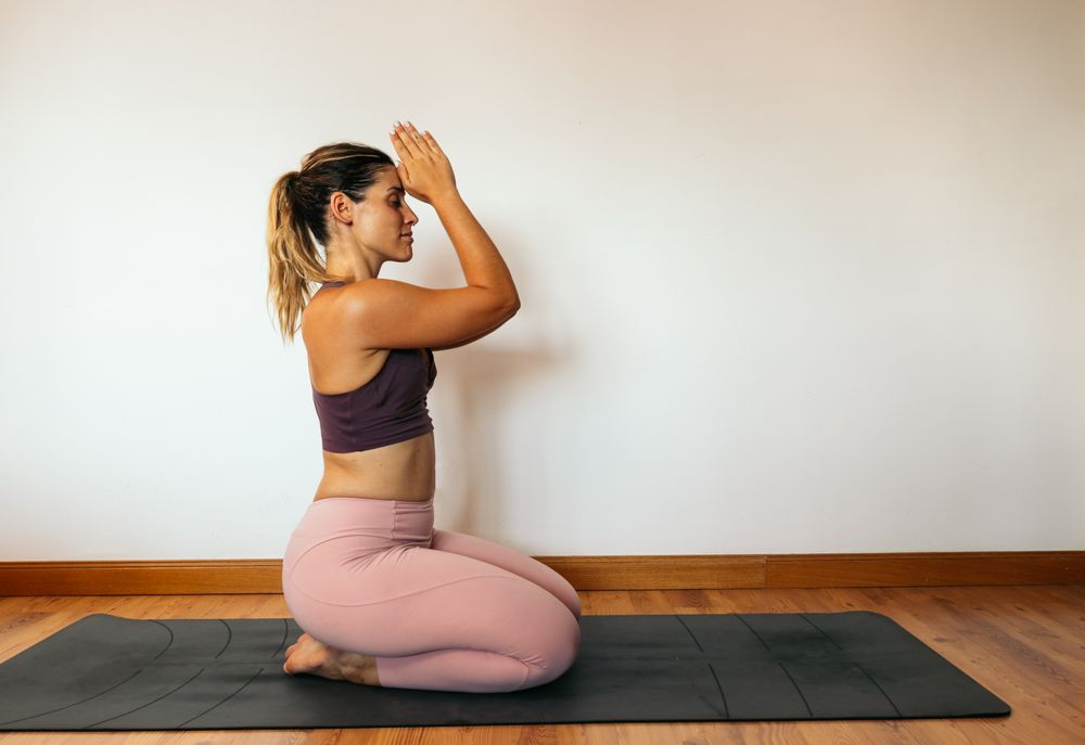 Woman in sportswear doing yoga at home