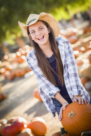 Girl Playing with a Wheelbarrow at the Pumpkin Patch.