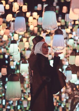 Tokyo, Japan - November 19th, 2019: Woman wearing a hijab interacting with art installation