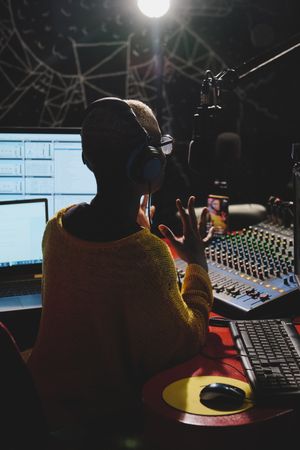 Unrecognizable Black woman in dark broadcast studio