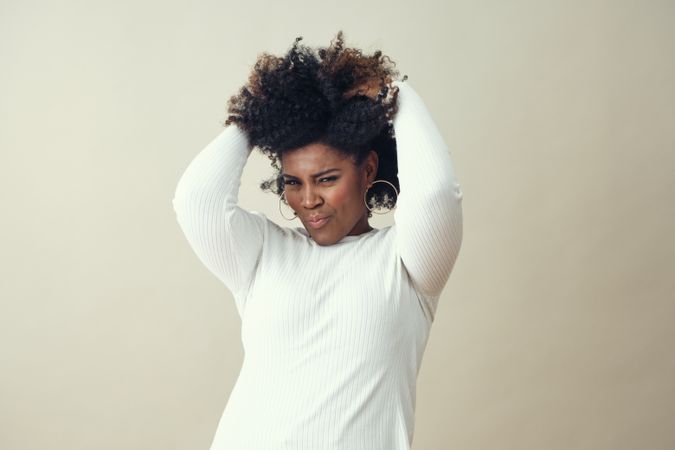 Portrait of playful Black woman running her hands through her hair