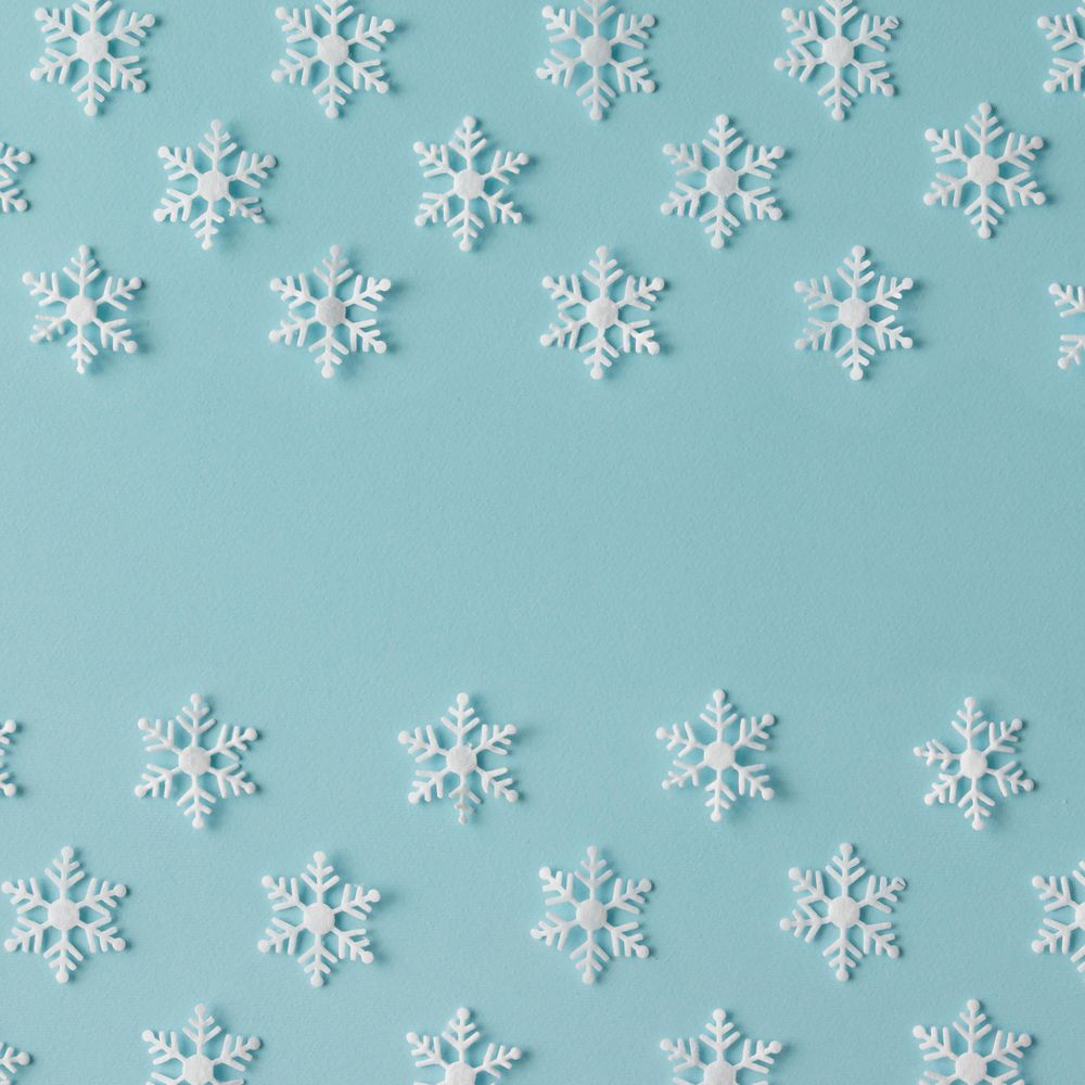 Winter pattern made of uniform snowflakes on blue background