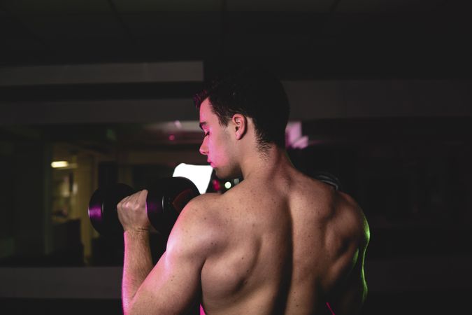 young fitness man doing weights