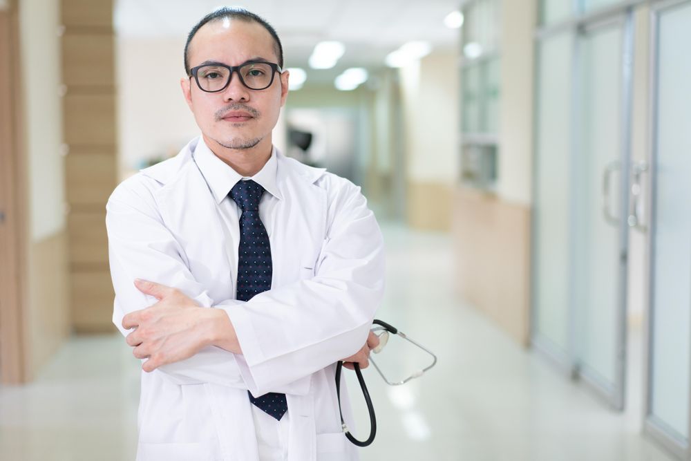 Serious doctor in bright hospital hallway