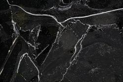 Fragment of thin ice on dark frozen river