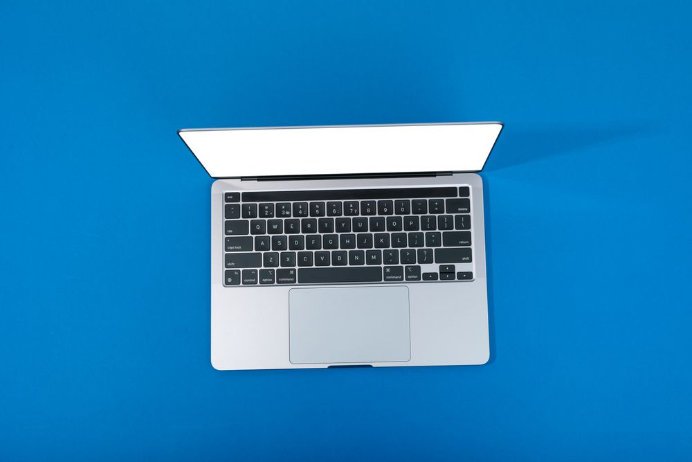 Looking down at blue room with laptop with mockup screen