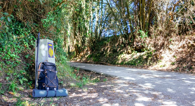 Milestone of Saint James way with backpack and hiking stick