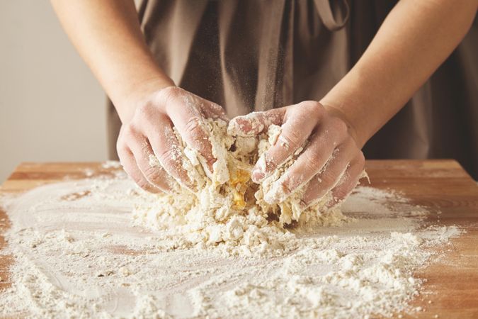Hands combining dough for pasta