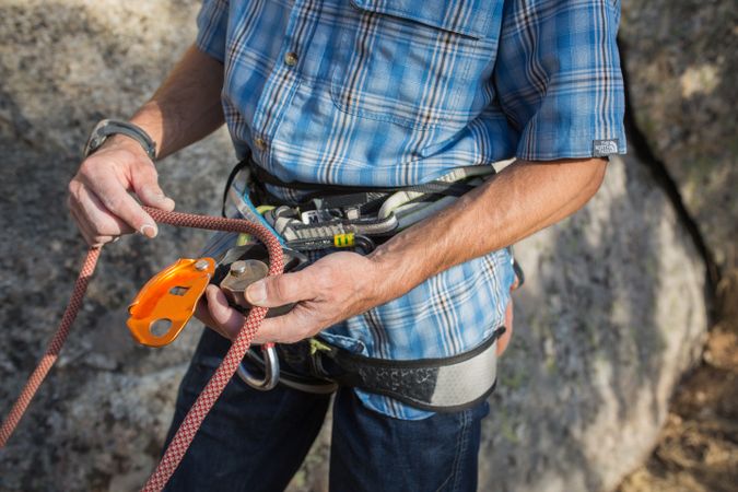 A climber is preparing his ropes to start climbing