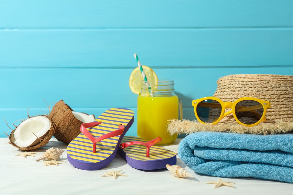 Summer vacation accessories on table against color wooden background, space for text. Happy holidays
