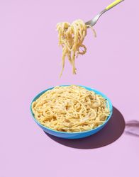 Eating pasta with a fork, minimalist on a purple background