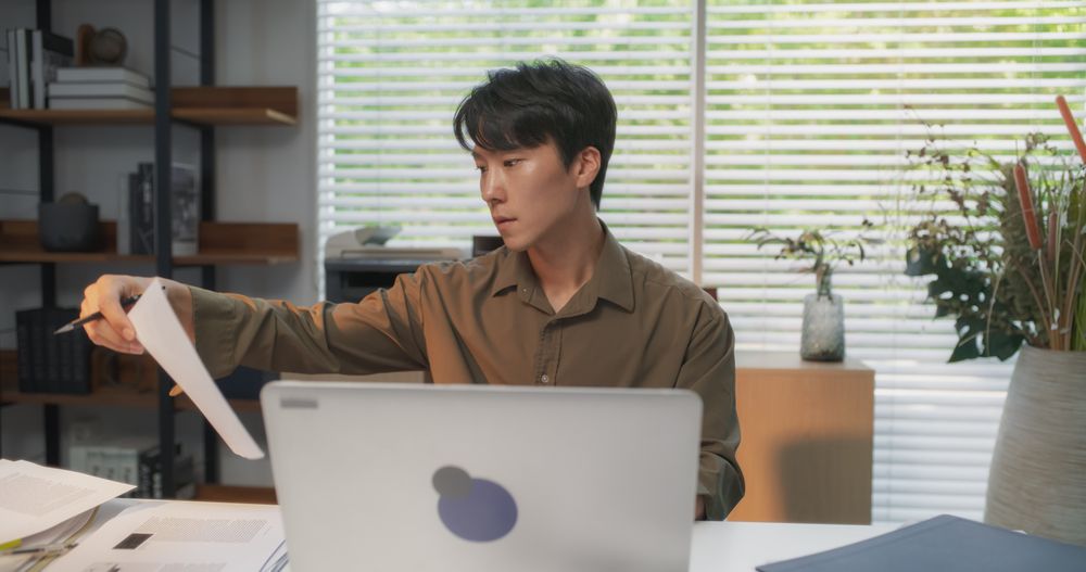 Talented South Korean Architect Using Laptop Computer at a Cozy Modern Workspace