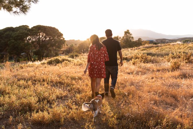 Happy active couple playing with dog outdoors