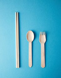 Chopsticks, spoon and fork on turquoise background