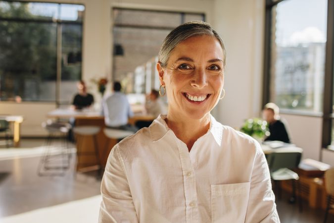 Mature woman standing in co-working space